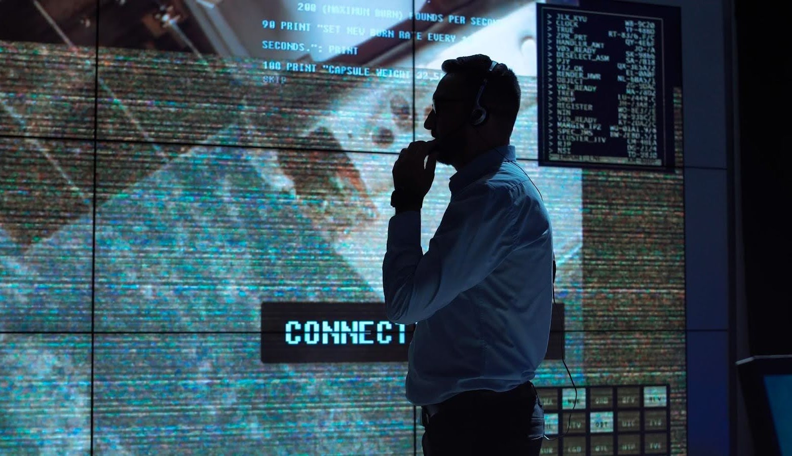 Person looking at screens with hand on their chin