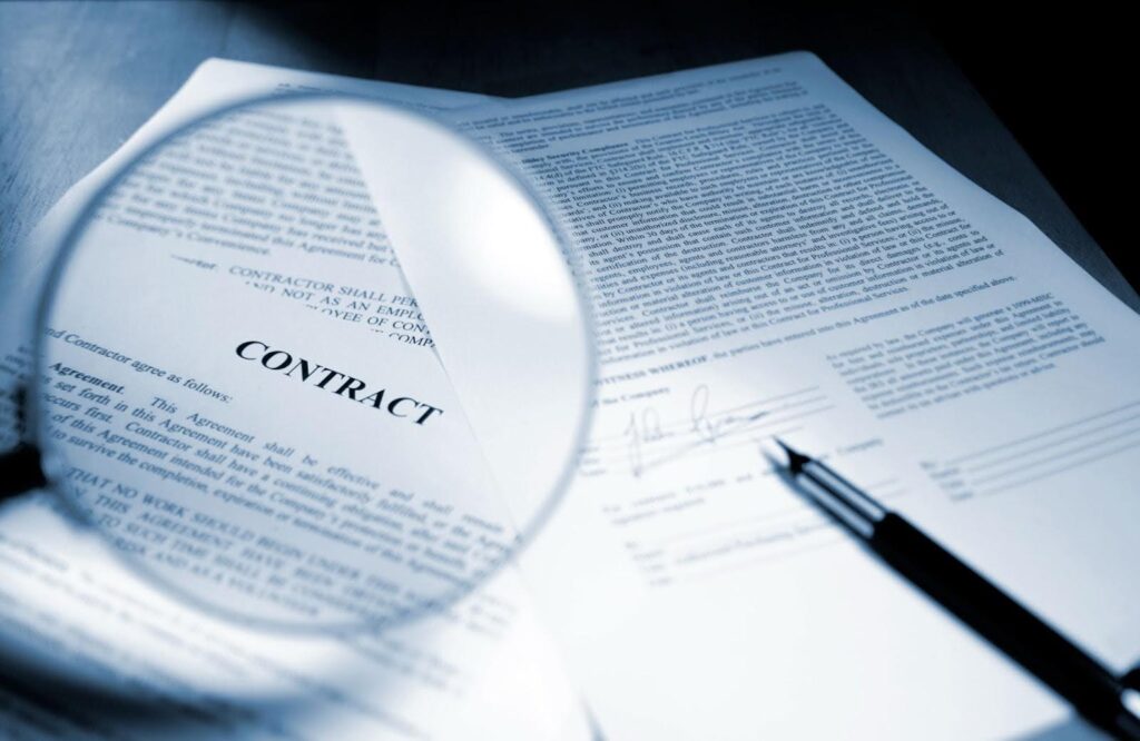 Several pages of a contract are displayed; a magnifying glass enlarges the word "contract" and the top of the first page.